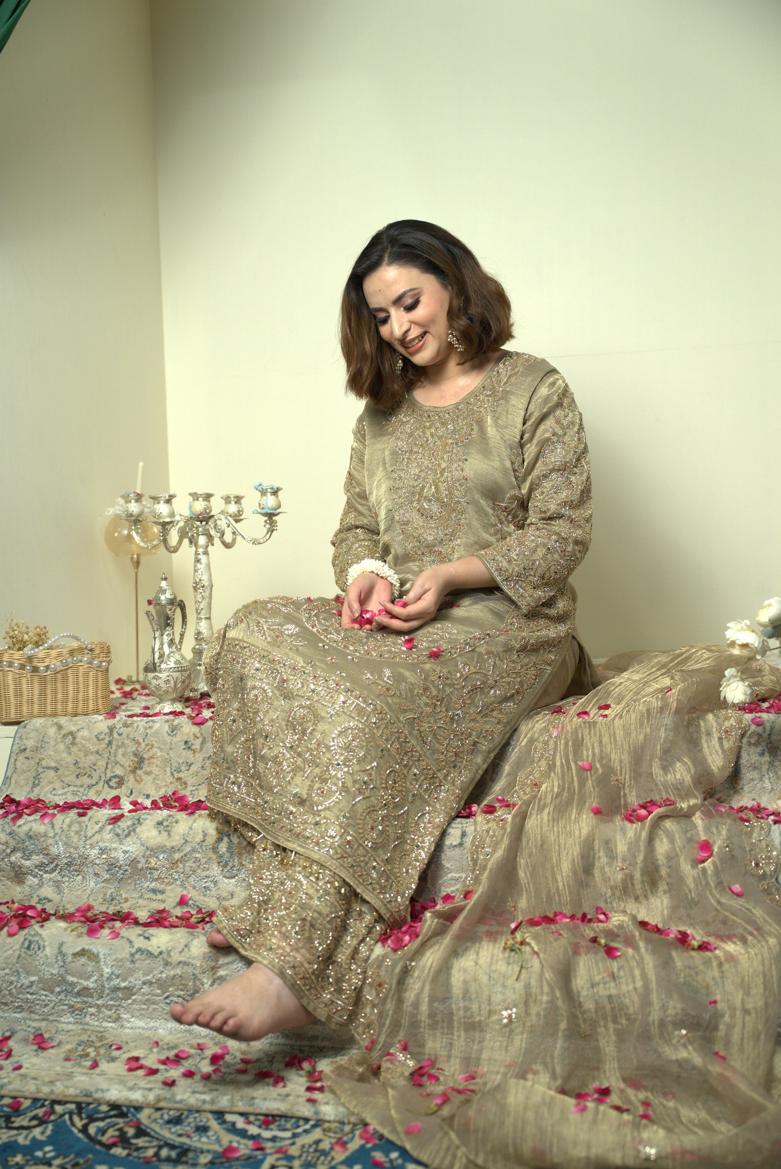 Olive-gold suit shown seated with its dupatta and embroidered detail visible